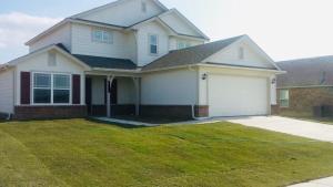 a white house with a driveway and a garage at The Cozy Haven in Owasso