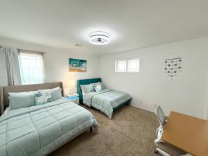 a bedroom with two beds and a desk at The Cozy Haven in Owasso