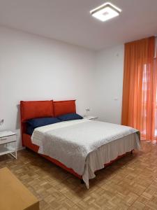 Un dormitorio con una cama grande con cabecero naranja. en Ambra Central Park - Giulia 19, en Trieste