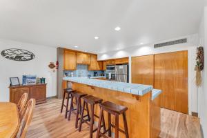 a kitchen with wooden cabinets and a bar with stools at LLC0804 - Lucky Lady 404 in South Lake Tahoe
