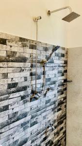 a brick wall with a shower in a bathroom at Simplex Sea Place in Tangalle