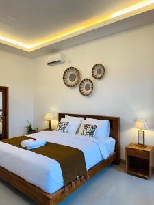 a bedroom with a large bed and two mirrors on the wall at South Hill Pandawa in Nusa Dua +26 photos