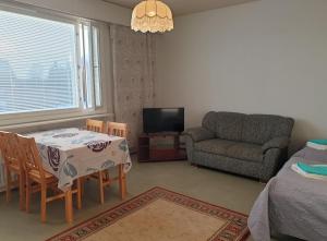 a living room with a table and chairs and a couch at Metsola in Pielavesi