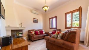 a living room with two couches and a fireplace at Villa Katerina BBQ & pool! in Metaxáta