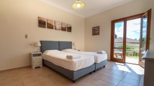 a bedroom with a large bed and a balcony at Villa Katerina BBQ & pool! in Metaxáta +36 photos