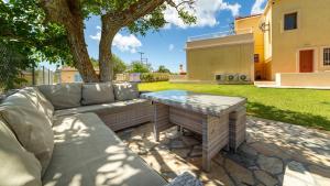 a patio with a couch and a table in a yard at Villa Katerina BBQ & pool! in Metaxáta