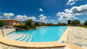 a swimming pool with blue water in a resort at Villa Katerina BBQ & pool! in Metaxáta
