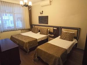 a hotel room with two beds and a window at Hasırcı Konakları in Amasya