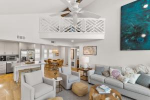 a living room with a couch and a ceiling fan at Oceanfront Escape A Coastal 3Br-2Ba Retreat With Stunning Views in New Smyrna Beach