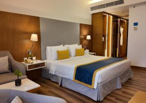 Ένα ή περισσότερα κρεβάτια σε δωμάτιο στο Golden Tulip Muscat