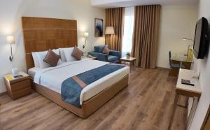 Ένα ή περισσότερα κρεβάτια σε δωμάτιο στο Golden Tulip Muscat