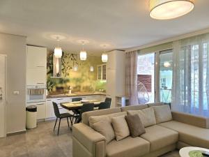 a living room and kitchen with a couch and a table at Olive Tree Apartment - 290 in Mullini i Danit