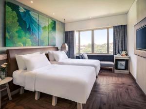 Postel nebo postele na pokoji v ubytování Mercure Kuta Bali