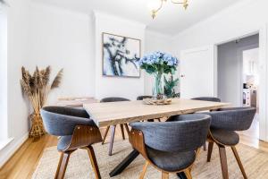 a dining room table with chairs and a vase of flowers at VAQUAY The Hamptons In Williamstown in Williamstown