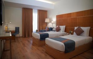 Ένα ή περισσότερα κρεβάτια σε δωμάτιο στο Golden Tulip Muscat