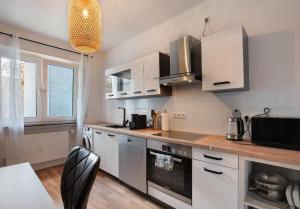 a kitchen with white cabinets and a black chair at Apartment Salvo in Mannheim