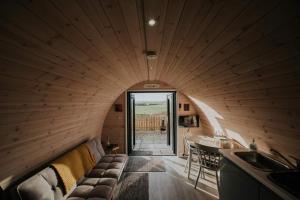 a living room with a couch in a wooden room at Ballyhemlin Pods - Haw thorn in Bushmills