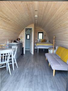 a living room with a couch and a table at Ballyhemlin Pods - Haw thorn in Bushmills +10 photos