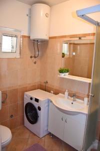 a bathroom with a washing machine and a sink at Apartments Mirela in Zaton