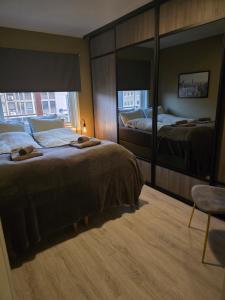 a hotel room with two beds and a mirror at Koselig og moderne leilighet, meget sentralt i Narvik med gratis parkering! in Narvik