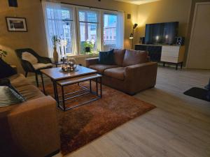 a living room with a couch and a coffee table at Koselig og moderne leilighet, meget sentralt i Narvik med gratis parkering! in Narvik