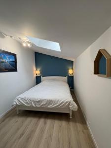 ラ・ベルヌリー・アン・レッツにあるMaison 43m2 meublée 200m plageのベッドルーム1室(青い壁の白いベッド1台付)
