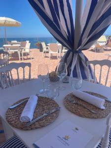 a white table with glasses and napkins on it at Hotel Albatros in Ischia