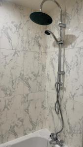a shower in a bathroom with a shower head at Tropical Sun Homes - Beautiful spacious 3 bed home in a serene environment with free parking for 2 cars in Manchester