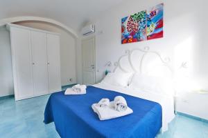 a bedroom with a blue bed with towels on it at Seashell apartment in Minori +16 photos