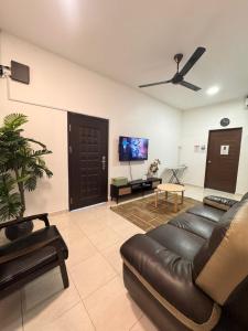 a living room with a leather couch and a flat screen tv at Tepi Villa Private Pool PD in Port Dickson +9 photos