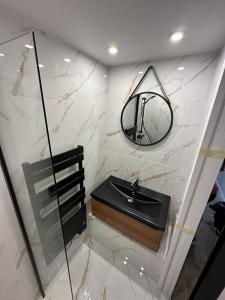 Un baño con un lavabo negro y un espejo. en Roméo et Juliette, en Cahors