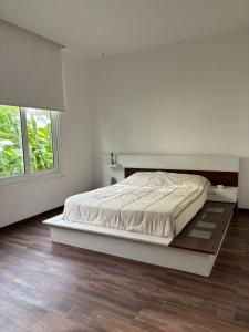 Un dormitorio blanco con una cama y una ventana. en Delta tigre Casa Aqua, en San Fernando