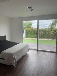 Un dormitorio con una cama y una ventana grande. en Delta tigre Casa Aqua, en San Fernando 17 fotos más