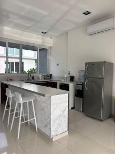 cocina con encimera grande y nevera en Delta tigre Casa Aqua, en San Fernando