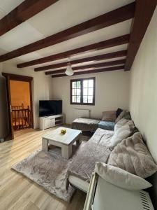 ein Wohnzimmer mit einer Couch und einem Tisch in der Unterkunft Propriété de charme avec vue panoramique in Mongauzy