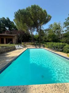 ein Swimmingpool mit blauem Wasser in einem Hof in der Unterkunft Propriété de charme avec vue panoramique in Mongauzy