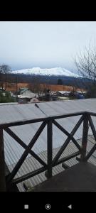 a wooden deck with snow covered mountains in the background at Cabaña Belén in Neltume +9 photos