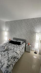 a bedroom with a large bed and a wall at BY NEPTUNE - Appartement Disneyland Paris in Chessy