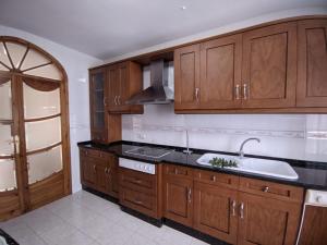 a kitchen with wooden cabinets and a sink at Casa de la Sirena in Baena