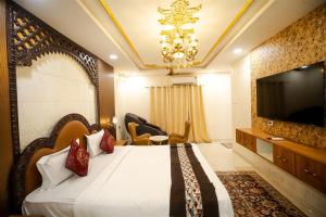 a hotel room with a bed and a television at RAJWADA RESORT & HOTEL in Raipur