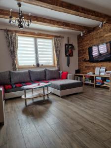 ein Wohnzimmer mit Couch und Tisch in der Unterkunft Chalupa nad sadom in Liptovská Kokava