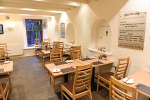 a dining room with wooden tables and chairs at Sandyford Hotel in Glasgow