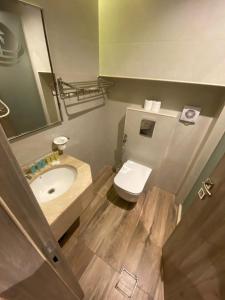 une salle de bain avec un lavabo, des toilettes et un miroir dans l'établissement Mass Paradise Hotel, à Aqaba