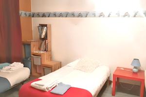 a room with two beds and a red table at Maison de charme à Primelin avec jardin et parking privé in Primelin