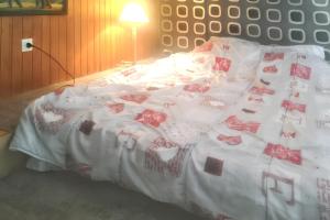 ラ・ブレスにあるAppartement cosy à La Bresse - 16 m² - Parking disponibleの赤いバラが飾られた白い掛け布団が敷かれたベッド