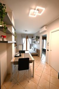 a kitchen and living room with a table and a couch at Appartamento Nettuno Casa di Romy in Nettuno