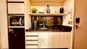 a small kitchen with a sink and a microwave at Maceió - Pajuçara - New Time Apt 516 in Maceió