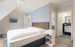 ein Schlafzimmer mit einem großen weißen Bett und ein Badezimmer in der Unterkunft Baltischer Hof Apartment 59 in Boltenhagen