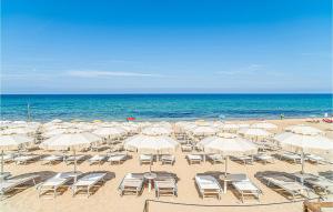 ein Strand mit Stühlen und Sonnenschirmen und das Meer in der Unterkunft Nice Apartment In Cavallino-Treporti in Cavallino-Treporti