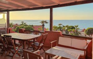 a patio with a table and chairs and the ocean at 2 Bedroom Beautiful Home In Castelsardo in Castelsardo +13 photos